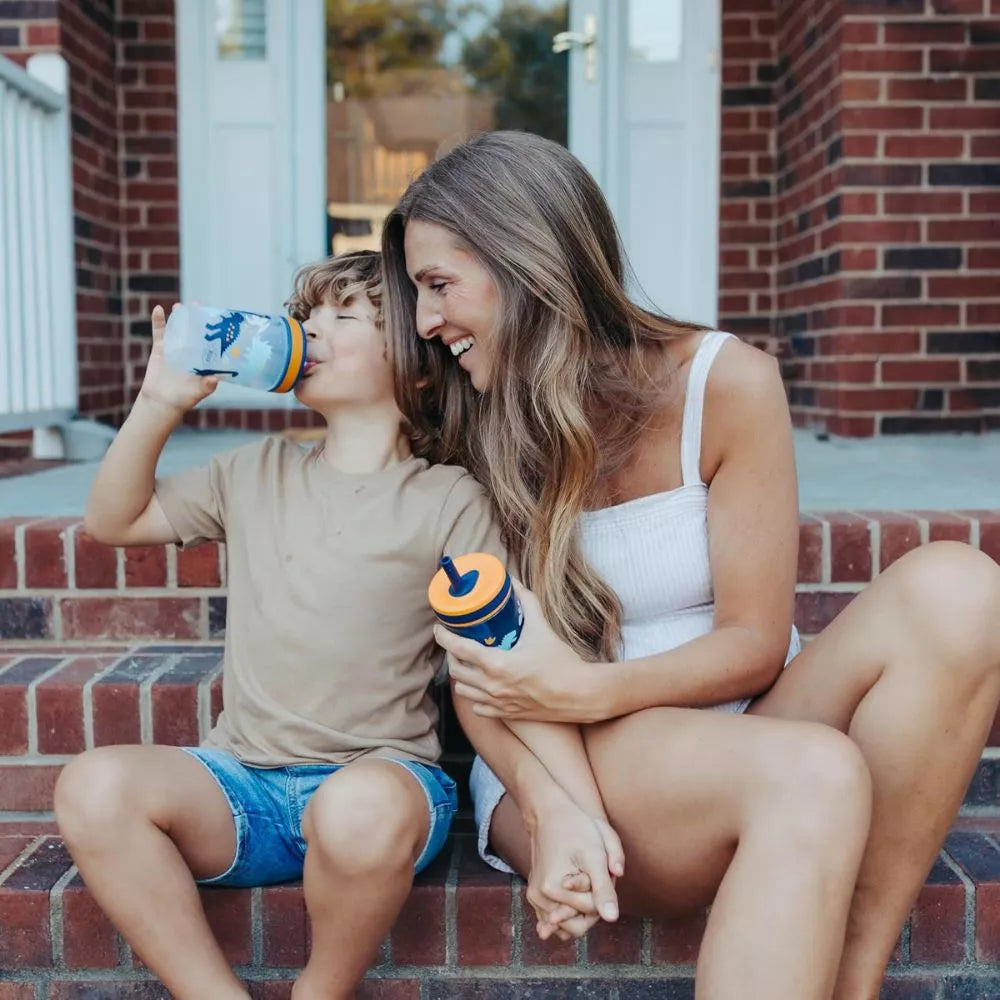 Child drinking from Zak Designs Kelso dinosaur straw cup during outdoor family time